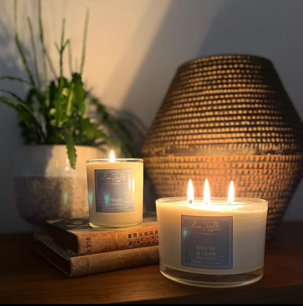 Warm Eve Taylor aromatherapy candles glowing in a peaceful Retreat setting.